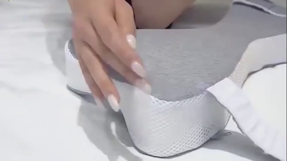 Fastening the Stay-Put Leg Pillow straps and lying on your side with it